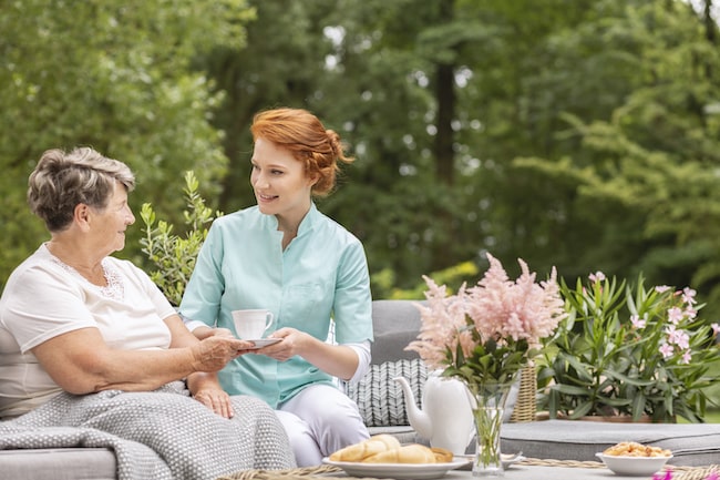 happy-nurse-giving-tea-to-elderly-woman-while-eati-2021-08-26-15-45-19-utc-1 (2)